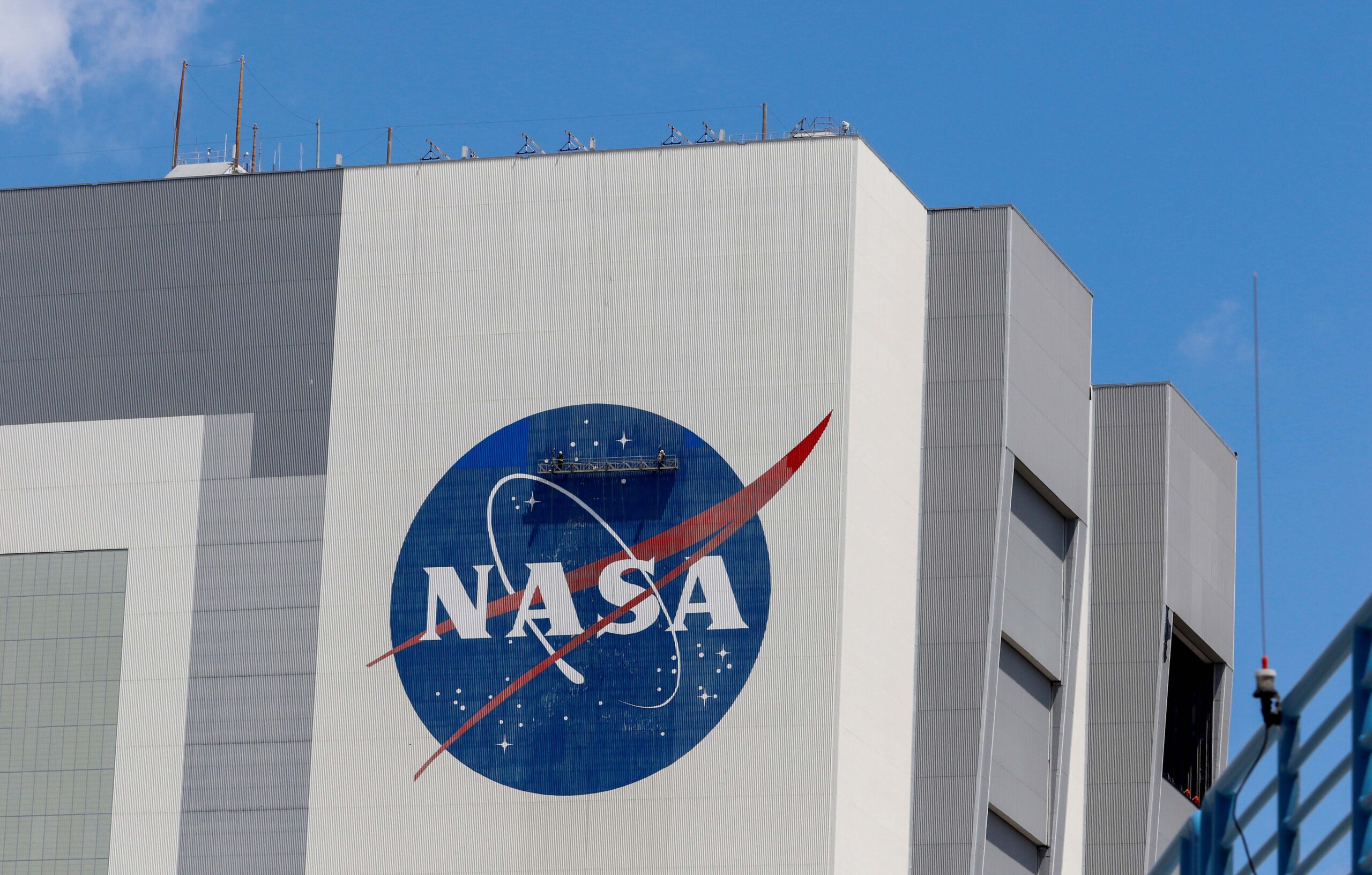 Workers pressure wash the logo of NASA on the Vehicle Assembly Building, in Cape Canaveral